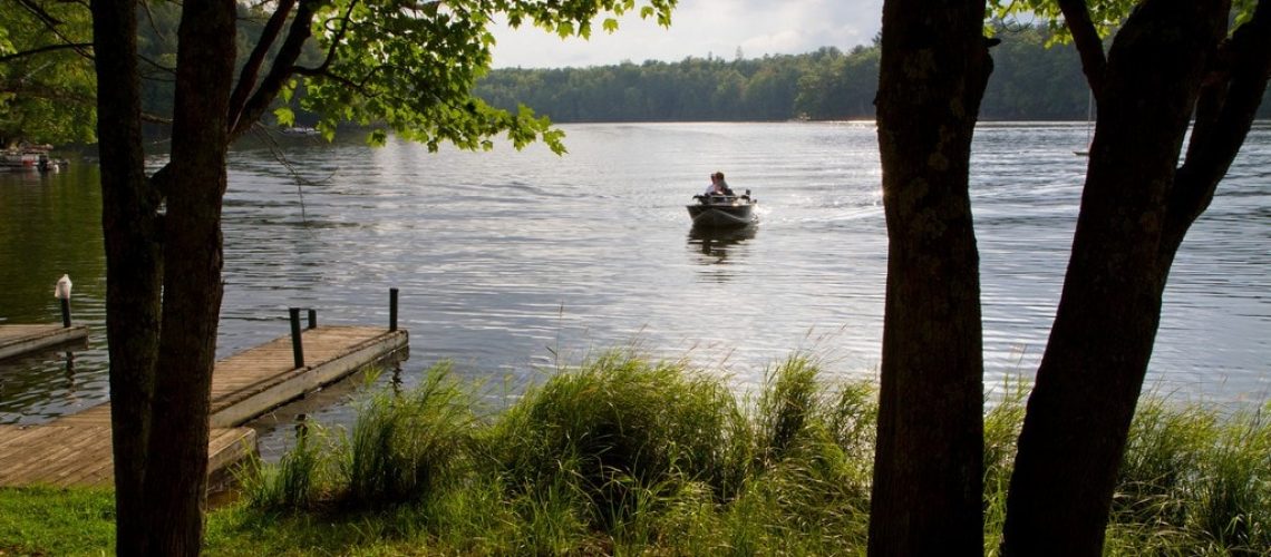 Fishing boat on a wilderness lake returning to a pier.